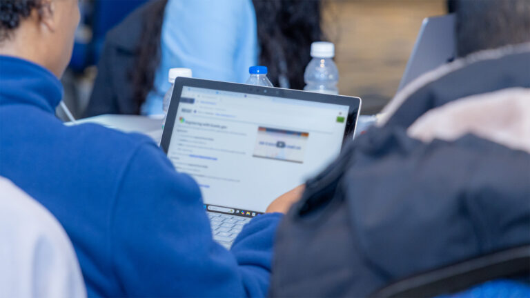A person looks at a laptop on a table.