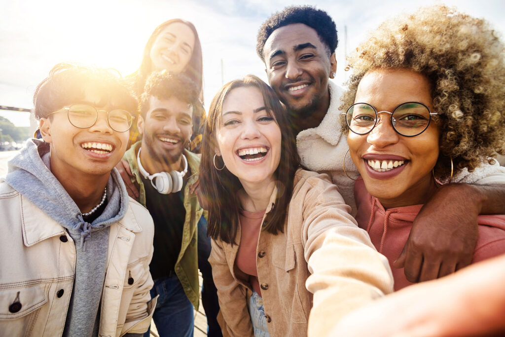 A group of friends smiling while posing for a selfie.