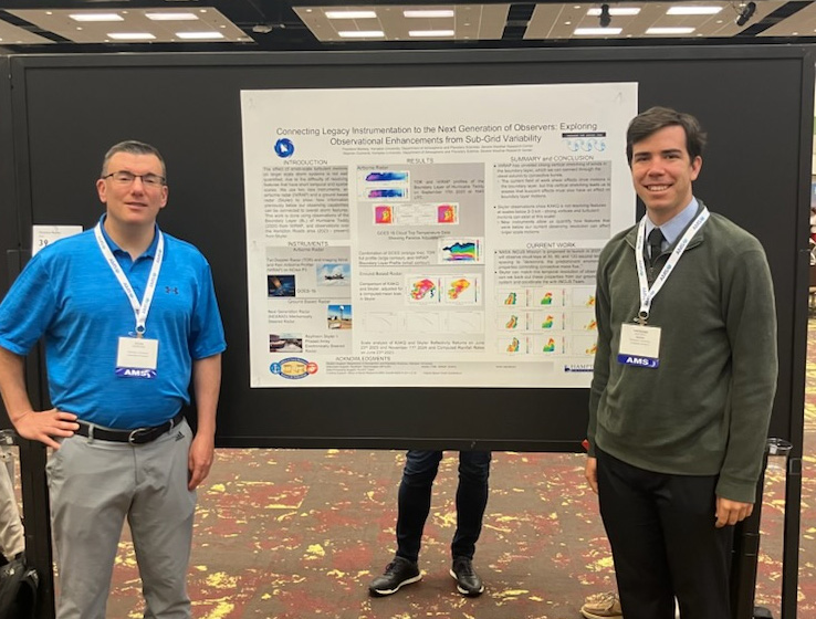 A photo of a professor and student presenting a poster board.