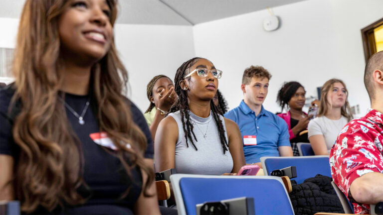 A photo of a group of onlooking students siting in an auditorium.