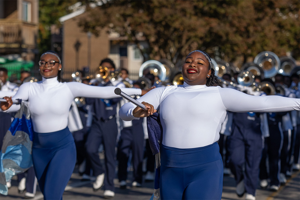 A photo of flag bearers marching in the parade ahead of the band.