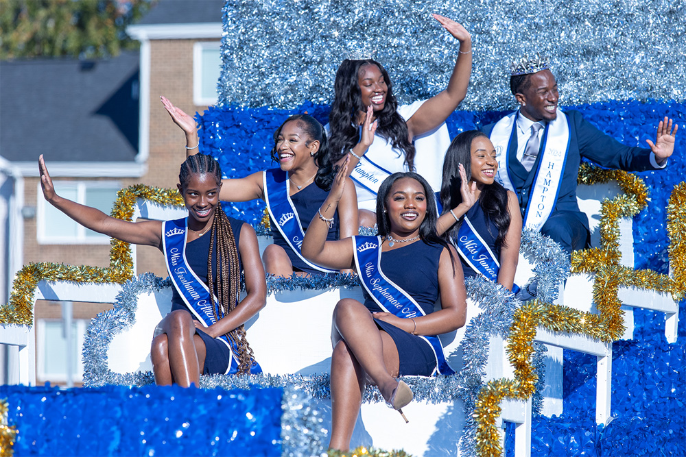 A photo of students waving while sitting on a float in the parade.