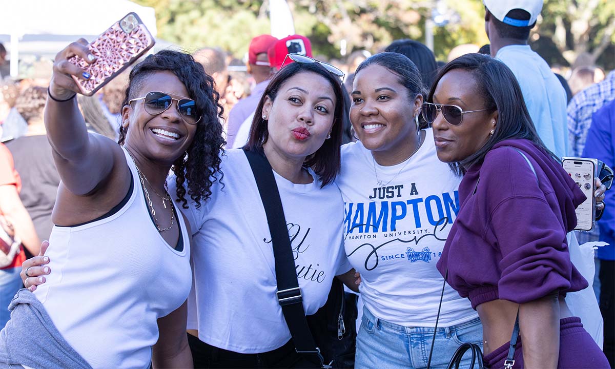 A photo of four HU alumni women posing for the camera.