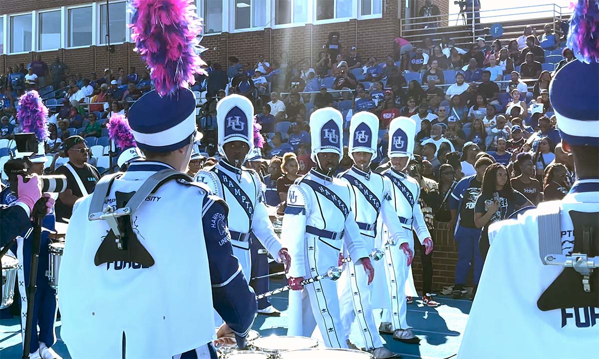 A photo of the Hampton University band walking through Armstrong Stadium during the Homecoming football game.