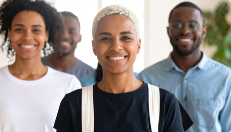 Photo of 4 people smiling facing the camera.