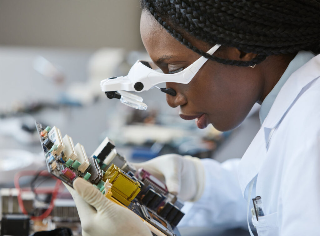 A student closely examines the circuitry on a motherboard.