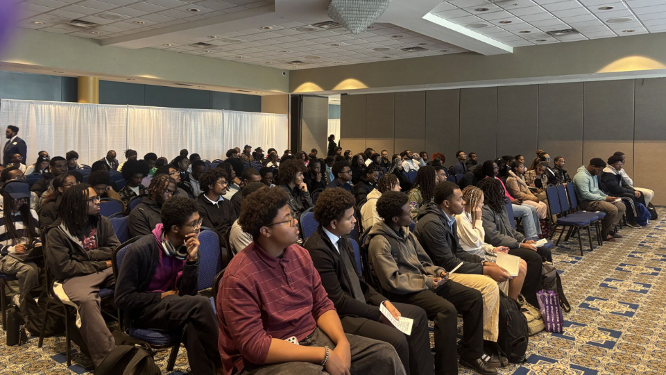 A photo of students sitting in the audience in an auditorium.