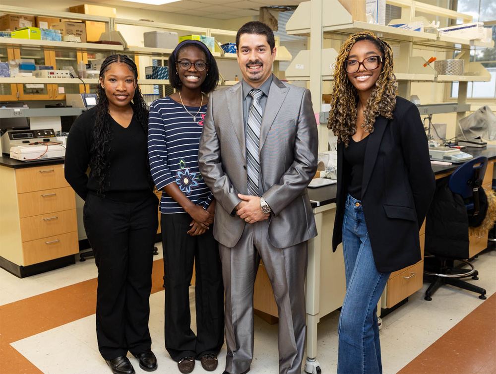 A photo of a professor and three students.