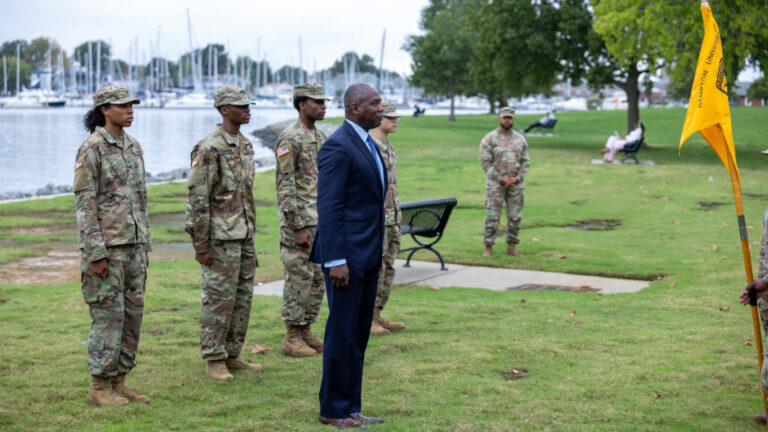 A photo of Darrel K. Williams standing at attention with army cadets behind him.