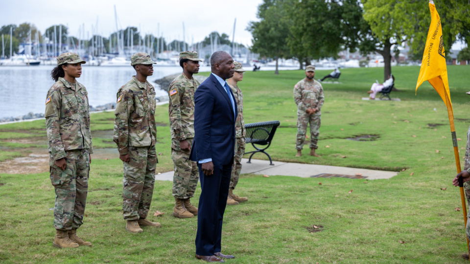 A photo of Darrel K. Williams standing at attention with army cadets behind him.
